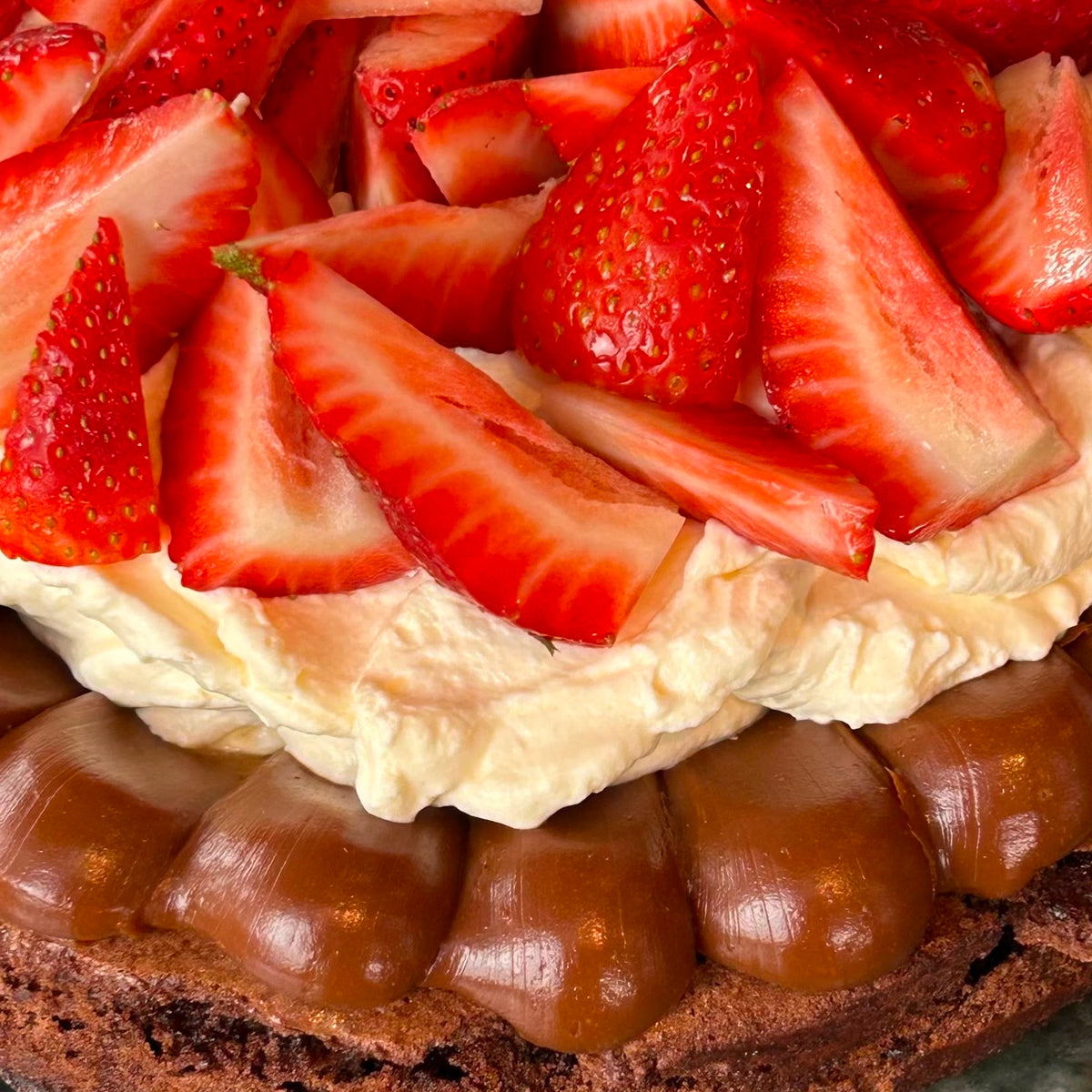 brownie con dulce de leche, crema y frutillas