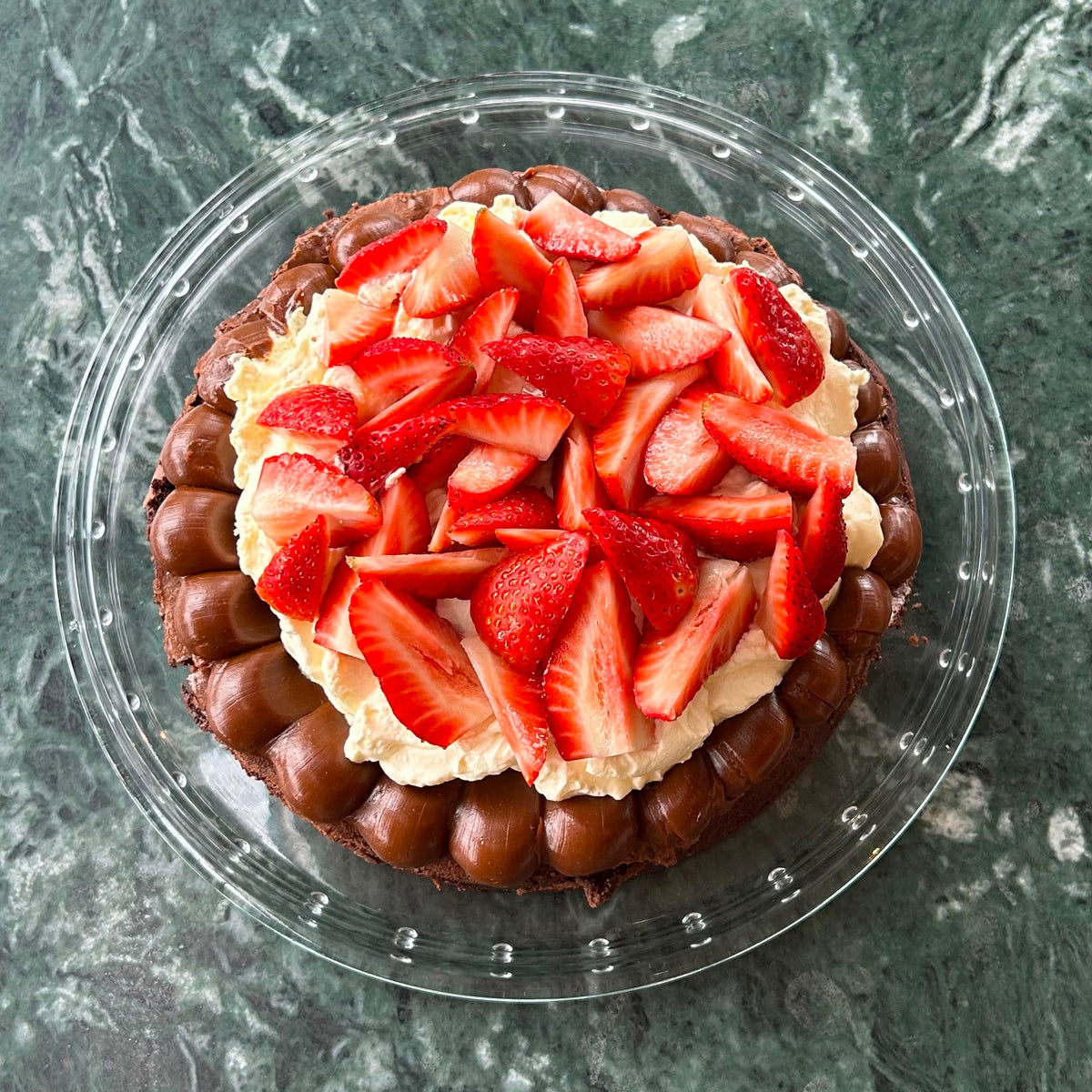brownie con dulce de leche, crema y frutillas